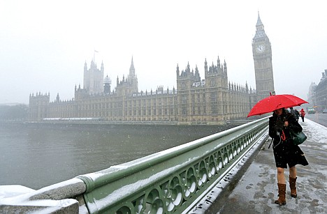 &lt;p&gt;A woman carrying a red umbrella walks across Westminster Bridge, with the Palace of Westminster in the background as it begins to snow in London, Friday. &#160;Snow is predicted to continue falling through the weekend.&#160;&lt;/p&gt;