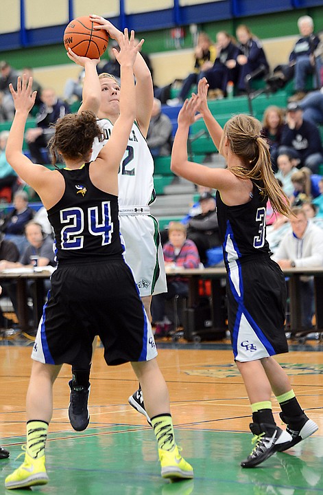 <p>Glacier junior forward/center Tessa Krueger (32) shoots over two Coeur dAlene, Idaho, defenders on Monday at Glacier High School.</p>