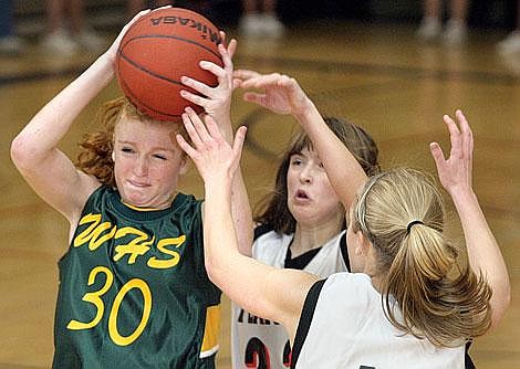 Whitefish&#146;s Tracy Schwada (30) battles for control of the ball against Flathead&#146;s Meghan O&#146;Connell, center, and Chaeney Latimer, right, during the second half of Thursday night&#146;s game at Flathead High School. The Bravettes defeated the Bulldogs 47-41. Craig Moore/Daily Inter Lake