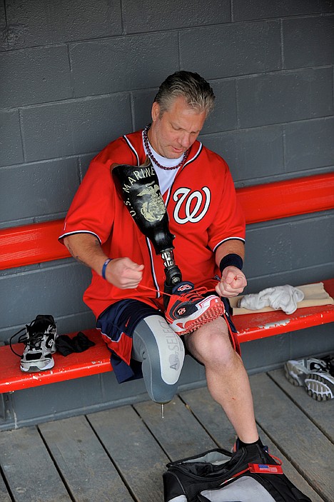 <p>Wounded Warrior Amputee Softball Team member Thomas Carlo laces up the shoe on his prosthetic leg before warming up for a Jan. 13 exhibition game.</p>