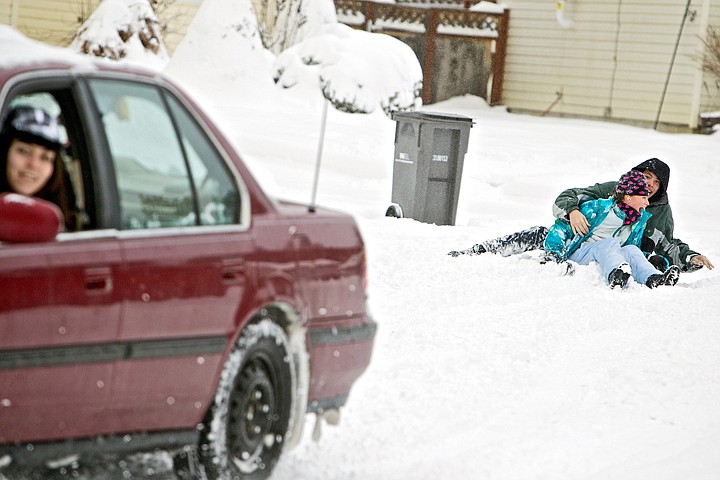 &lt;p&gt;JEROME A. POLLOS/Press Jayden Requena, 18, keeps an eye on her &quot;hookybobbin&quot; team that fell off their sled while she was towing them behind her car Friday. Evan Puskash, 15, and Faith Nelson, 10, used their snow day away from school to their advantage by being pulled around their Coeur d'Alene neighborhood with hot chocolate breaks between sessions.&lt;/p&gt;