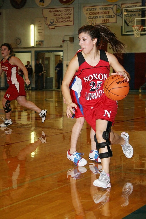 Lady Red Devil Rachael Stettler dribbles the ball up court during a game against Superior Saturday evening.