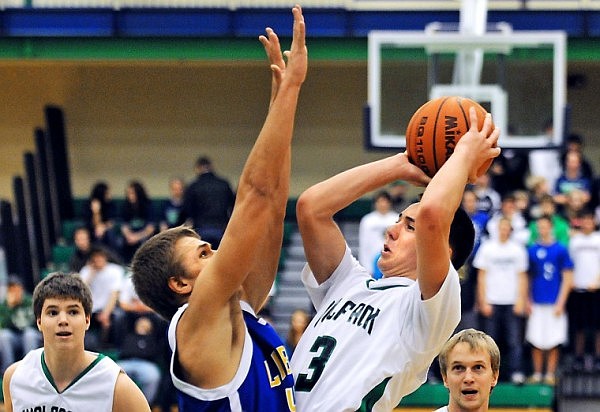 Glacier's Trey Griffith (3) leans back in mid-air to shoot the ball over Libby's Alex Cislo during Friday evening's home game.