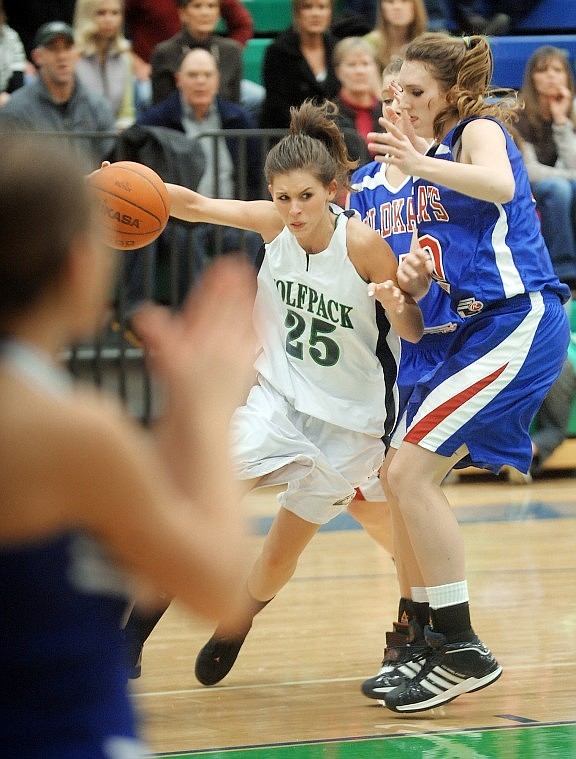 Glacier senior Brooke Watkins (25) pushes her way toward the basket around Columbia Falls senior Kelsey DeWit (40) during their game on Friday. Glacier won 48-45.