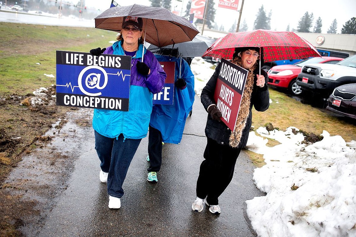 &lt;p&gt;Pam Cosselboom, left, and Joan Neary brave the rain on Saturday to express their anti-abortion beliefs as they walk along U.S. 95 in Coeur d'Alene with more than one hundred other people also protesting abortion.&lt;/p&gt;