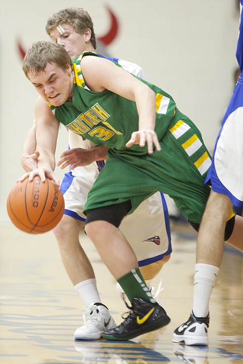 <p>Whitefish guard Cooper Olson (30) fights his way past Bigfork
Vikings defender Austin Jordt Thursday night at Bigfork High
School.</p>