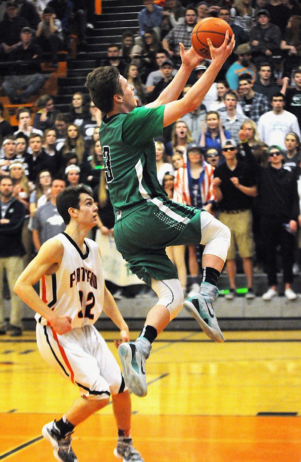 <p>Glacier's Blayne Bailey sails past Flathead's Tyler Johnson to score a layup to help the Wolfpack pull away from the Braves. (Aaric Bryan/Daily Inter Lake)</p>