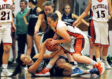 <p>Glacier's Hailey Ruggles fights with Flathead's Kylee Meredith for a loose ball as Hailee Bennett looks on during the first half of the Wolfpack's 59-36 crosstown victory at Flathead on Tuesday. (Aaric Bryan/Daily Inter Lake)</p>