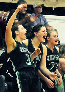 <p>The Wolfpack's Taylor Salonen (3), Nikki Krueger (21), and Anna Schrade (23) celebrate from the bench after a basket in the final minutes of their victory against Flathead. (Aaric Bryan/Daily Inter Lake)</p>