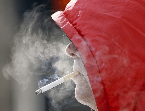 &lt;p&gt;A man smokes in Omaha, Neb., in February 2007. Annual health care costs are roughly $96 billion for smokers and $147 billion for the obese, the government said.&lt;/p&gt;