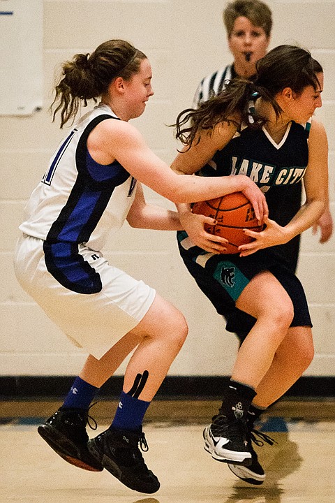 <p>Coeur d'Alene High School's Erin Legel gets a hold of the ball while Lake City's Alyssa Kacalek receives a pass in the first half.</p>