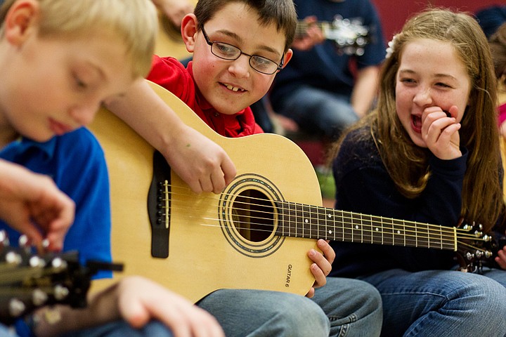 &lt;p&gt;SHAWN GUST/Press Sam Catanzaro, a fifth-grade student, center, laughs with Sarah Salyer while watching Payton Spencer tune a guitar Tuesday during a music class at Skyway Elementary in Coeur d'Alene. The guitars and accessories were purchased as part of an EXCEL grant that will be used in a semester-long curriculum.&lt;/p&gt;