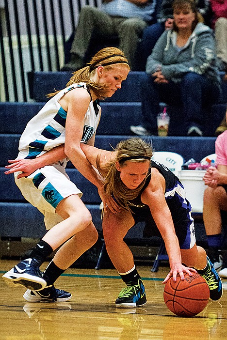 <p>Madison Sumner, guard for the Coeur d'Alene Vikings, reaches for a loose ball while blocking Lake City's Jansen Butler.</p>