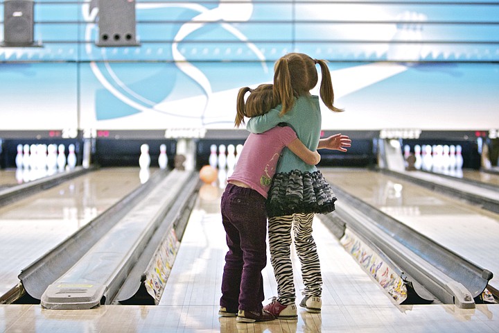 &lt;p&gt;JEROME A. POLLOS/Press Bailey Burke, 3, holds onto her sister Madison, 5, as they patiently wait for their bowling ball to slowly make its way down the lane Thursday as it skids off the bumper at Sunset Bowling in Coeur d'Alene. The girls made their first bowling trip with their mom as part of a food drive for the Idaho Connections Academy.&lt;/p&gt;