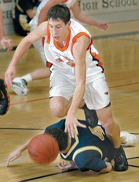 Flathead guard Jeremy DeHerrera runs over Big Sky&#146;s Sean Rabe while in pursuit of a loose ball during first-half action Friday in Kalispell. Flathead won 73-54. Karen Nichols/Daily Inter Lake