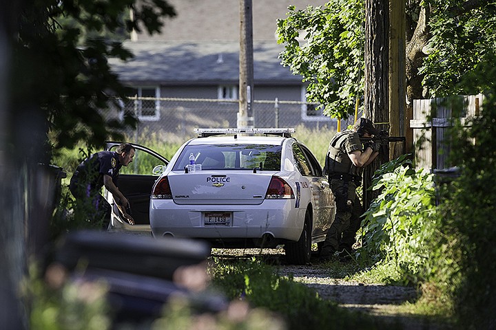 &lt;p&gt;SHAWN GUST/Press Dressed in full tactical gear, an officer takes aim on the back side of a home on the corner 7th Street and Hattie Avenue Monday, July 1, 2013 as a Coeur d'Alene Police Department officer crouches behind a squad car during a standoff that closed several streets in the area for several hours.&lt;/p&gt;