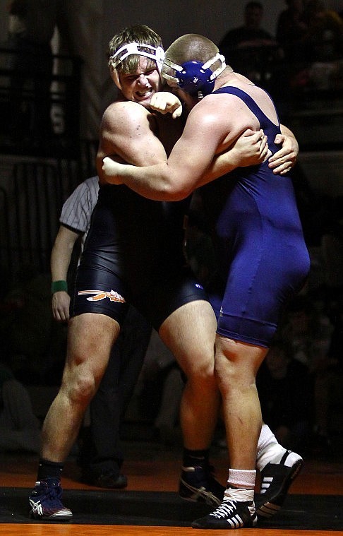 Flatheads Connor Thomas grits his teeth as he wraps his arms around Glaciers Dan Gilbert in a heavyweight match.
