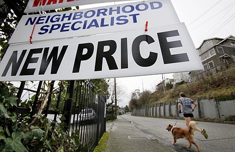 &lt;p&gt;A jogger and dog run past a house posted with a new price Tuesday in Seattle. Home prices are falling across most of America's largest cities, and average prices in eight major markets have hit their lowest point since the housing bust.&lt;/p&gt;