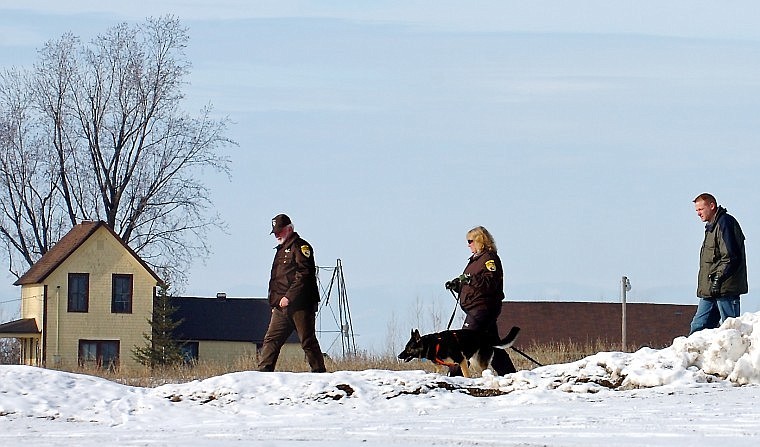 Flathead County Sheriff’s Posse members, from left, Perry Gates and Janet Yatchak and Sheriff’s Detective Ray Young search for evidence while walking between a home at 729 Mennonite Church Road and the Mountain View Mennonite Church. The home was the site of a hostage situation Wednesday night.