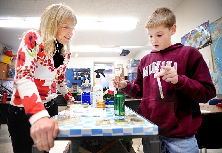 Dover works with sixth-grader Bryer Anderson on his project testing what objects people come in contact with that carry the most infectious organisms.