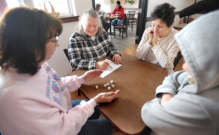 From left, Staci Mastne, of Columbia Falls, Glenda Bowman, Bonnie Hellen, and Diane Puchalski, all of Kalispell, play a round of Farkle on Friday at the Adult Day Treatment Center in Kalispell.
