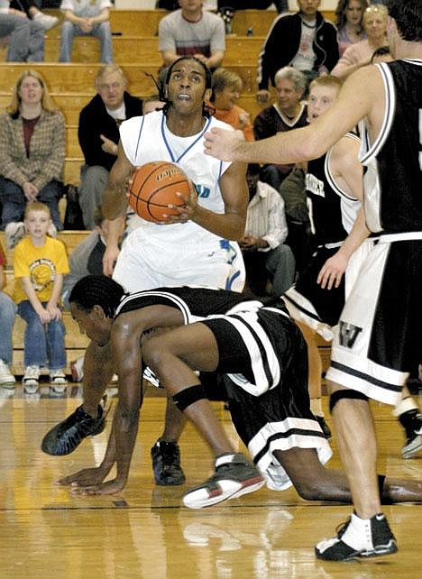 Brad Redford/ Columbia Basin Herald<br>Big Bend's Antonio Walker goes up for a shot with Wenatchee Valley's Rashea Dozier falling into him during the second half on Saturday. Walker scored nine points, all in the second half during one of Big Bend's runs to put the game away at 92-72.