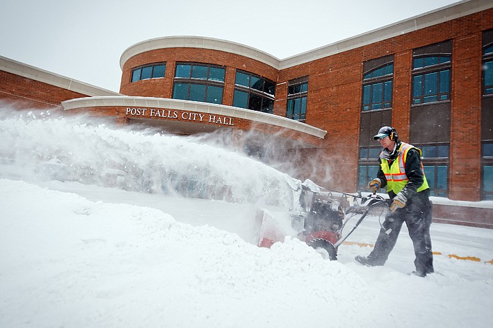 &lt;p&gt;JEROME A. POLLOS/Press Bryan Myers clears snow from the driveway of the City Hall entrance Wednesday in Post Falls as the snow continues to fall.&lt;/p&gt;