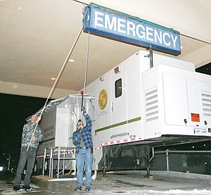 &lt;p&gt;Tony Rebo left, and B.J. Purdy cover the emergency entrance sign to St. John's Lutheran Hospital.&lt;/p&gt;