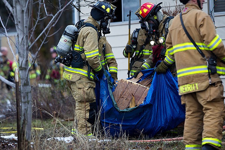 &lt;p&gt;Kootenai County firefighter Rusty Kramer and Lieutenant Frank Harwood carry wood panels from a house that suffered from an electrical fire on Cecil Road in Post Falls on Tuesday afternoon. The fire was caused by a electrical splice that overheated in-between the walls of the bedroom causing minimal damage.&lt;/p&gt;