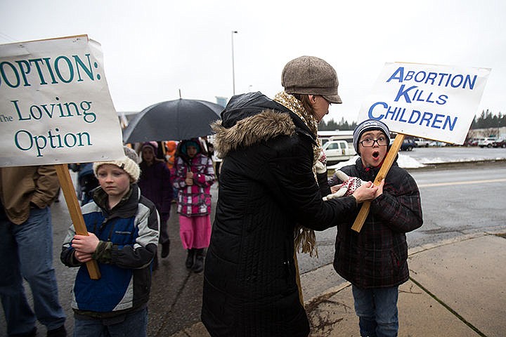 &lt;p&gt;Erin Wright helps her son Caleb Wright, 8, put on his gloves during a &#147;commemorative march and rally&#148; organized by the local Right to Life chapter in Coeur d&#146;Alene. The event started with speakers Nancy Tefft with Open Arms Pregnancy Care Center and Real Choices Clinic and Dr. Thomas deTar and was followed by a march down Highway 95.&lt;/p&gt;