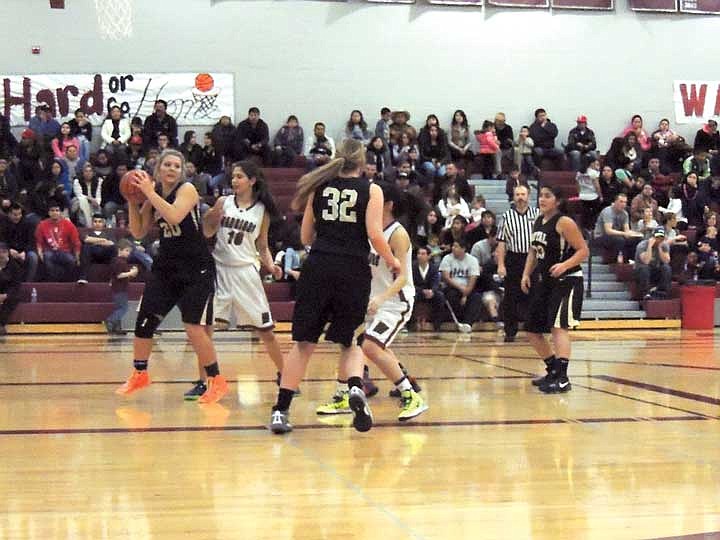 Royal's Kailee Harris uses her height advantage to snatch a rebound, but finds it difficult to trigger a fast break because of Gissell Torres's&#160; defense during last Saturday's SCAC East basketball win for Royal. The Knights were too tall for the Warriors.