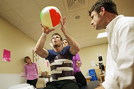 &lt;p&gt;Using a beach ball during a therapy session with Allstot, right and physical therapist Sarah Gross, Mike Vredenburg focuses on keeping his balance and learning how to use a different set of muscles to perform tasks following a spinal cord injury.&lt;/p&gt;