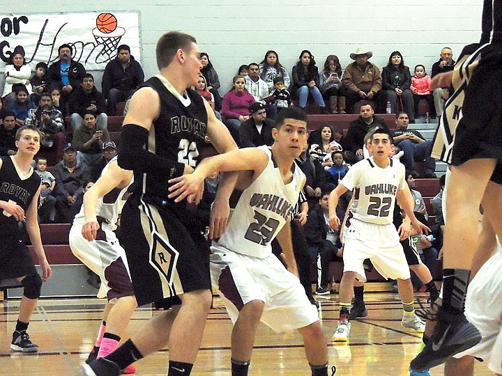 Saul Ramos, 23, of Wahluke checks Teddy Mead of Royal so tightly that he traps his arms in last Saturday's 72-47 SCAC East basketball victory by Wahluke. The Warriors employed a stingy defense and a speedy offense.