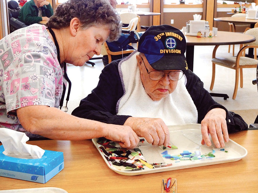 &lt;p&gt;Warren Jones receives help from Montana Veterans Home activity aide Norma Leib while creating a mosaic piece that will be fused and strung into wind chimes. Art produced by Veterans Home residents is on display through this month at Stumptown Art Studio. (Sue Cox/Stumptown Art Studio)&lt;/p&gt;