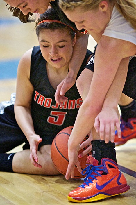 <p>Whitney Gonzales from Post Falls High tries to secure a loose ball as her teammate Katie King leans over her and Lewiston High's Karlee Wilson attempts to knock the ball away in the second half.</p>