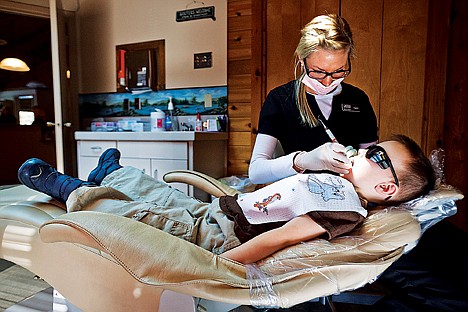 &lt;p&gt;Kami Nielsen, dental hygienist for Avondale Dental Center, cleans the teeth of five-year-old Jacob Osterdock Friday during the Give Kids a Smile Day. The event, in its ninth year, offers tens of thousands of dollars worth of dental work to uninsured children at no cost each year.&lt;/p&gt;