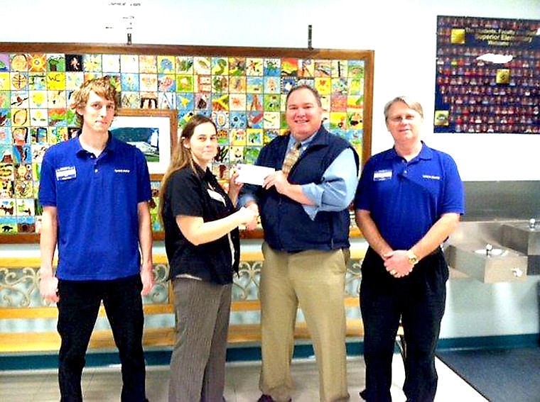 <p>Superior Elementary School Principal Scott Kinney accepts a check from Town Pump store manager Heather Seaman as Joe Hummel and Tom Woody stand by as witnesses.</p>