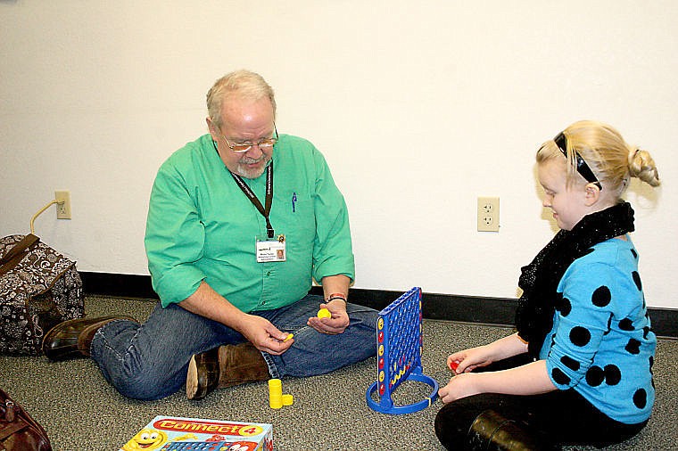 <p>Monte Turner and Kassidi Scott play a game at the Mineral Regional Health Center's health coverage fair at the Superior ambulance facility.</p>