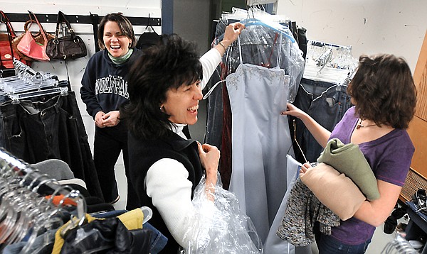 Glacier's Carrie Power, left to right, Flathead's Sylvia Heselwood, and Flathead junior Kristen Hegenbarth, 17, sort and arrange clothes on Wednesday afternoon at the Crosstown Closet.