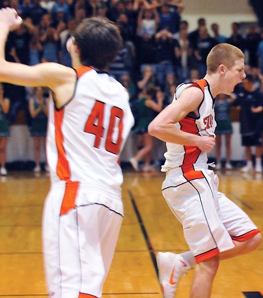Flathead's Ian Gillespie, right, celebrates hitting a three point shot at the buzzer to send the game into overtime.