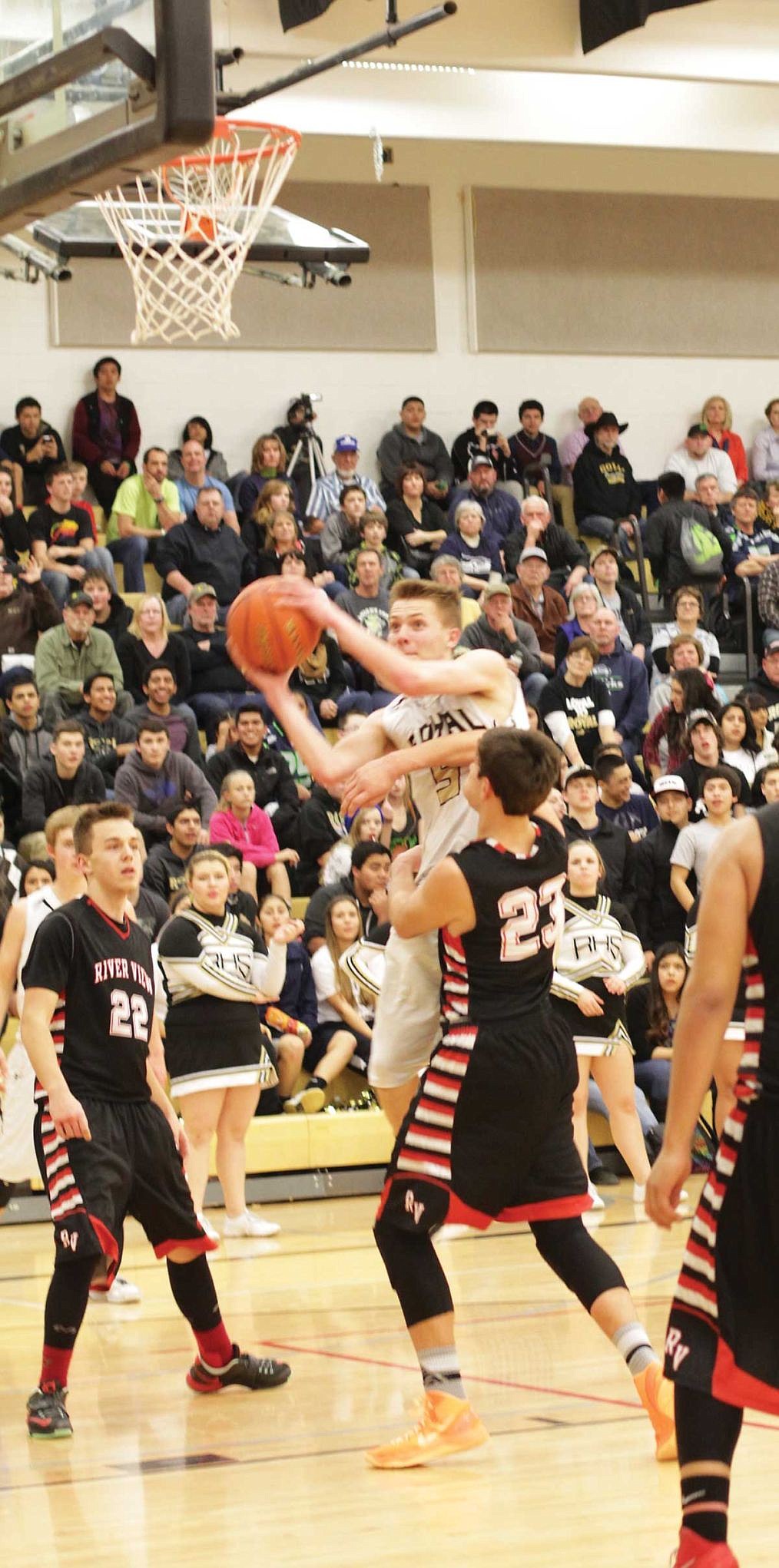 A River View defender wraps his left arm around Royal's Chase Christensen as he launches from the free throw line.