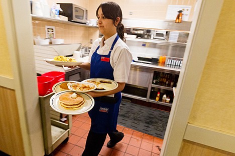 &lt;p&gt;Lisa Marinez, a server at IHOP, delivers several plates including an order of flap jacks during her shift.&lt;/p&gt;