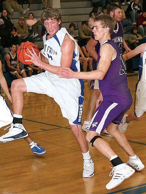 Photo by Ed Moreth&lt;br&gt;Bluehawk Mike Woods snatches a rebound from Viking Chico Stipe at Thompson Falls. The Bluehawks won 77-36.