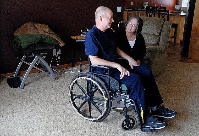 Geri Cochrane sits next to her husband Dave in the living room of their rural Columbia Falls home, which recently was equipped with a wheelchair ramp and railings by a crew from Plum Creek, where Dave worked for many years. &#147;It&#146;s been life-changing to learn to adapt to all of this,&#148; Geri said.