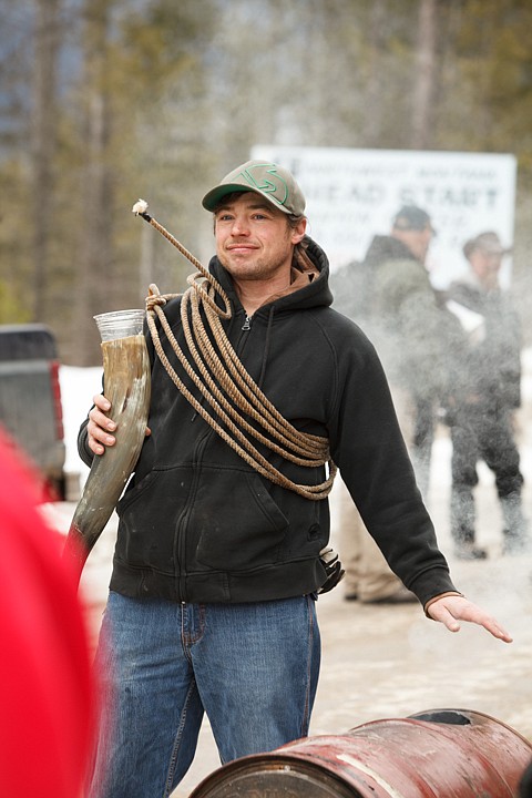 <p>Matt Thompson of Whitefish warms his hand over a barrel filled with burning wood Saturday afternoon during the World Championship Barstool Races at the 35th Annual Cabin Fever Days in Martin City. "I call it the 'Hot Seat,'" said Thompson. Saturday, Feb. 9, 2013 in Martin City, Montana. (Patrick Cote/Daily Inter Lake)</p>