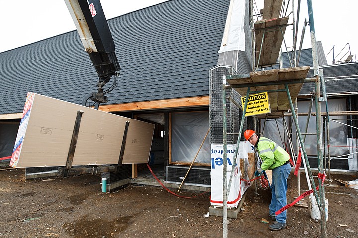 &lt;p&gt;Nathan Shaw, a drywall installer for Building Specialties, designates a danger zone with warning tape Monday while unloading an order of drywall materials at a Coeur d'Alene Construction site.&lt;/p&gt;