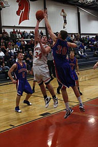 Wade Bache narrowly gets a shot attempt off over the outstretched arm of a Bigfork defender during the Horsemen's 23-53 loss on Friday.