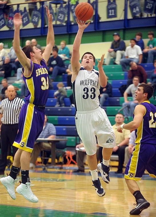 Glacier senior Connor Fuller (33) shoots under pressure from Sentinel defenders Riley King (33) and Kendal Maier (22) on Tuesday.