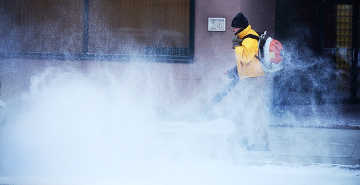 &lt;p&gt;Ron Trippet uses a backpack blower to clear snow from the sidewalk Friday morning along First Avenue East near Center Street in Kalispell.&lt;/p&gt;