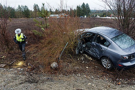 &lt;p&gt;Trooper Holly Branch, with the Idaho State Police, investigates the area around a vehicle that was involved in a collision in the nearby intersection of U.S. 95 and Lancaster Road on Monday in Hayden. Both passengers of the sedan were transported to Kootenai Health in critical condition. The male driver was air-lifted and a female passenger was transported by ambulance.&lt;/p&gt;